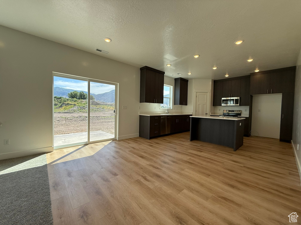 Kitchen featuring stainless steel appliances, light countertops, plenty of natural light, recessed lighting, and light wood-style flooring