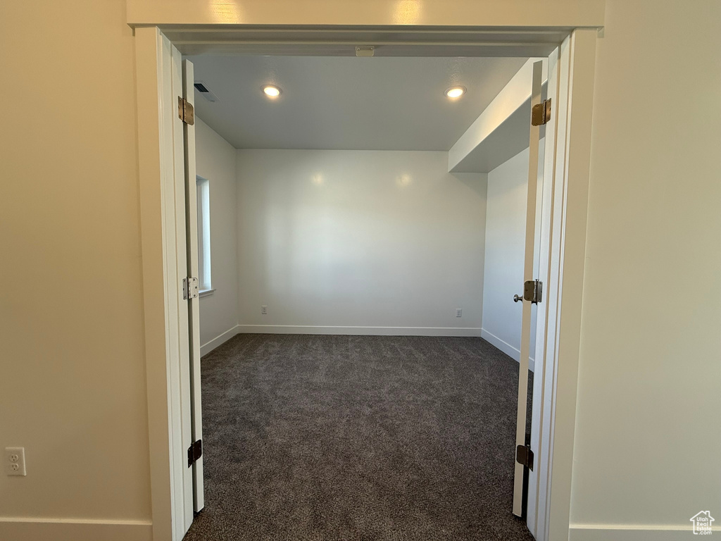 Spare room with dark colored carpet and recessed lighting