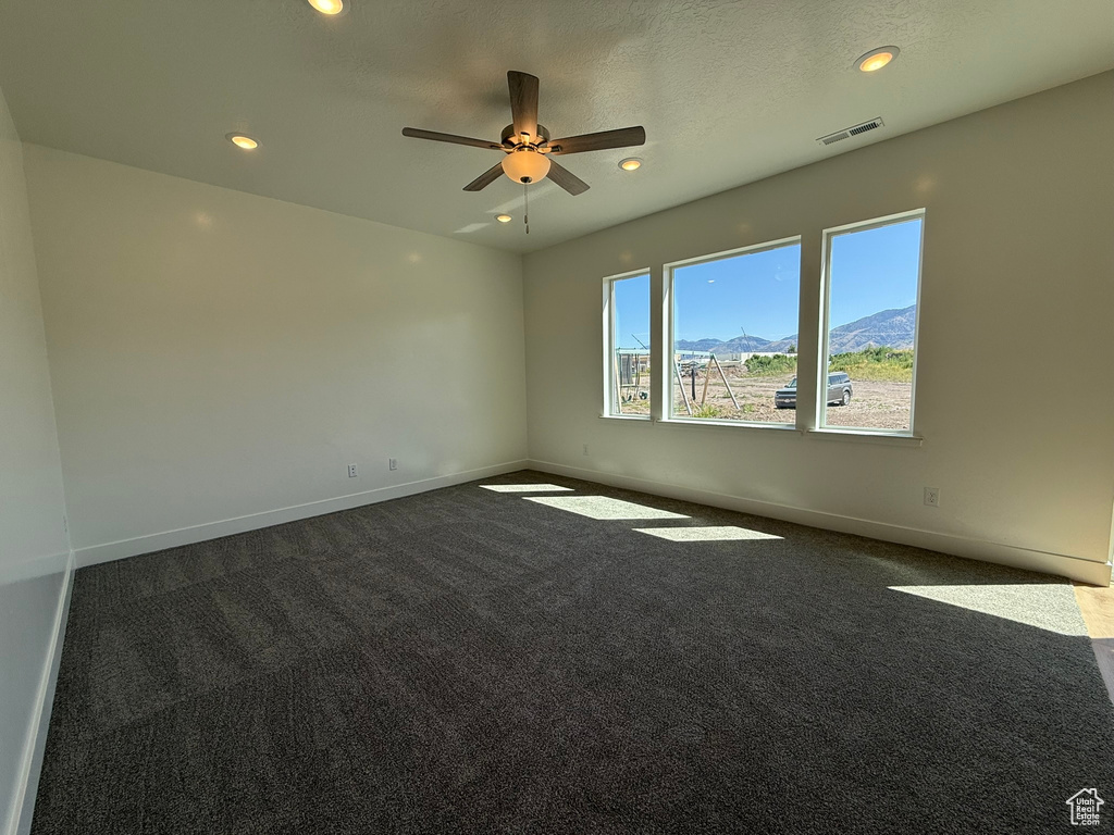 Unfurnished room featuring dark colored carpet, a ceiling fan, and recessed lighting