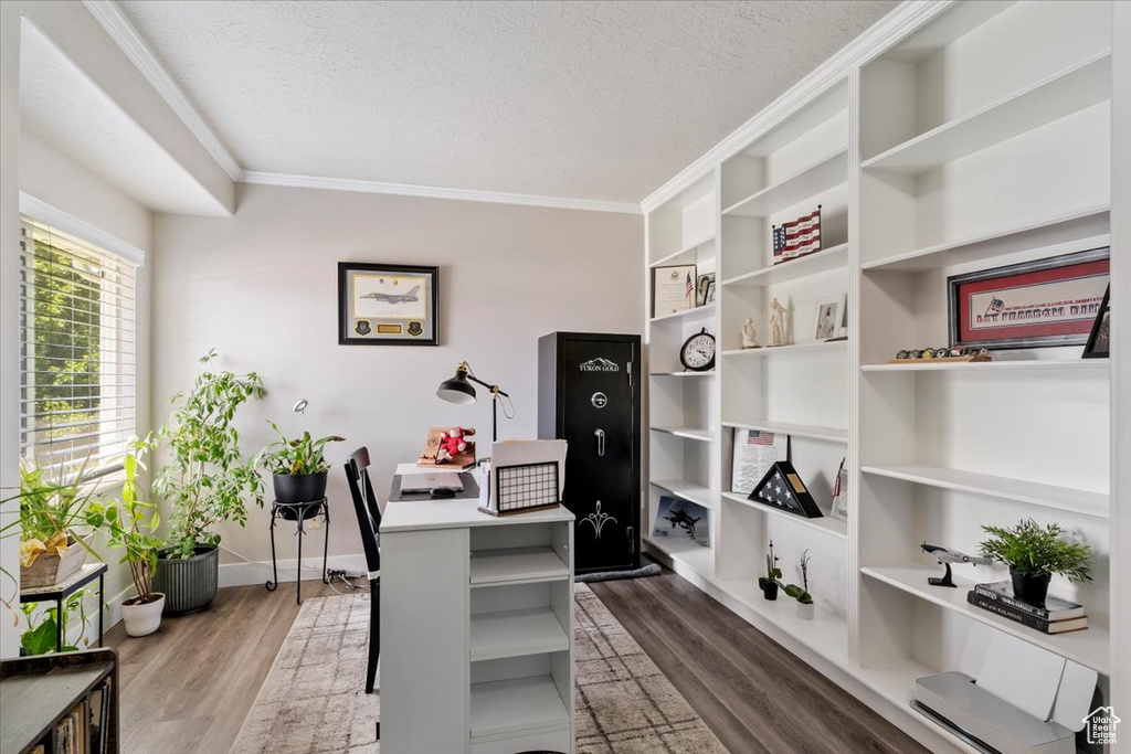 Office with a textured ceiling, ornamental molding, and wood finished floors