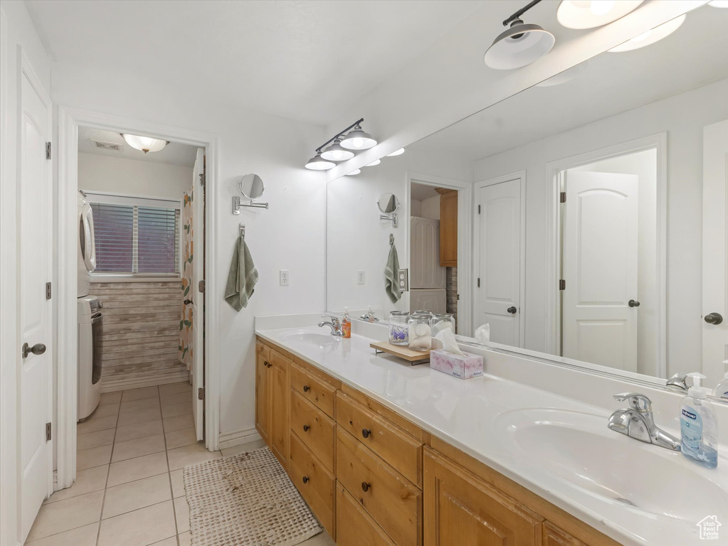 Bathroom featuring double vanity, washer / clothes dryer, and tile patterned flooring