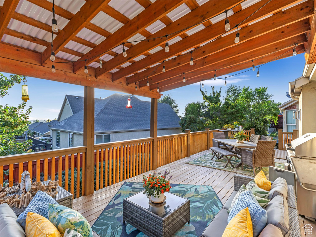 Wooden terrace with an outdoor living space, outdoor dining area, and a pergola
