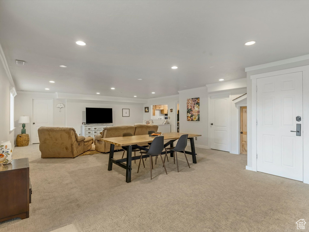 Dining space with recessed lighting, light colored carpet, and crown molding