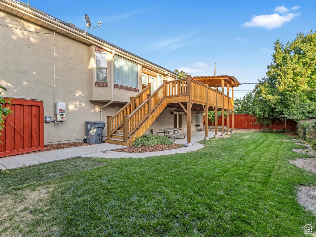 Rear view of house featuring stairway, a wooden deck, stucco siding, and a patio