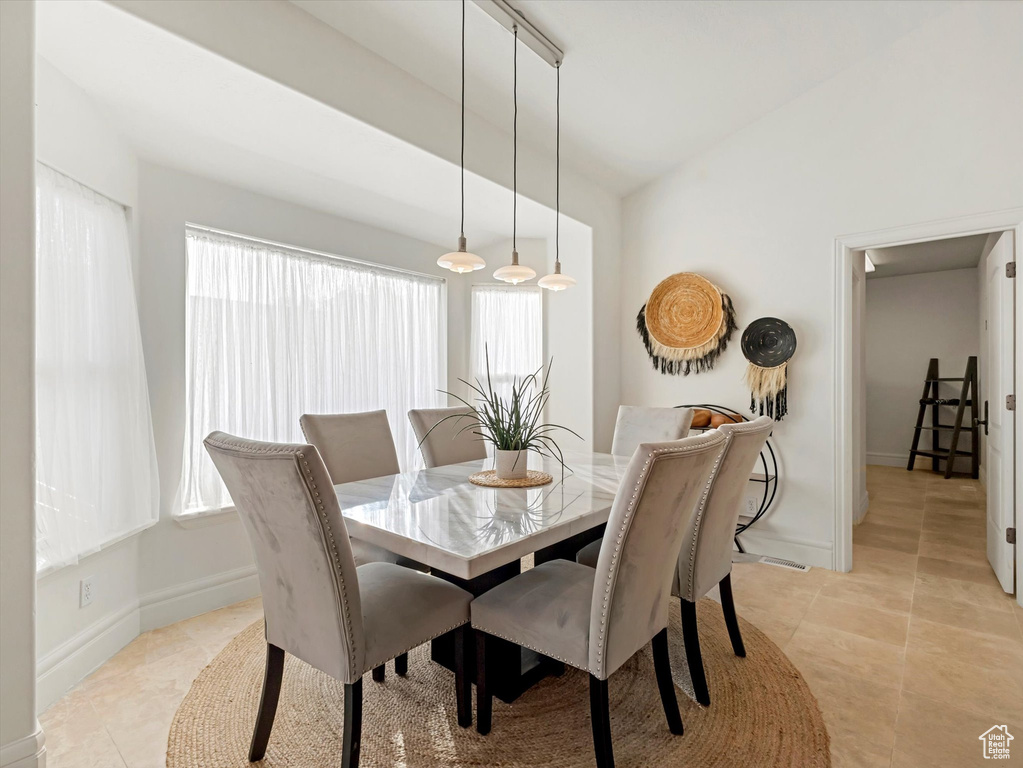 Dining area with lofted ceiling and light tile patterned floors