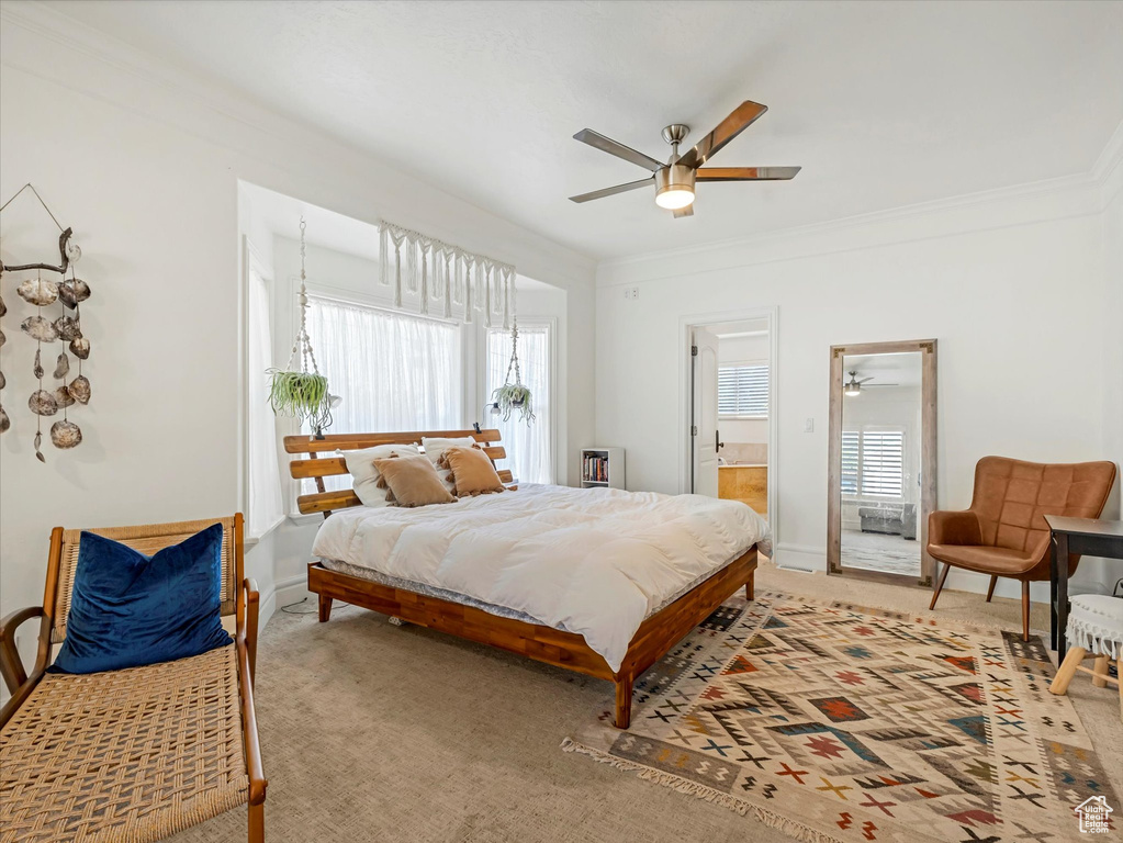Bedroom with light colored carpet, ornamental molding, ensuite bathroom, and a ceiling fan
