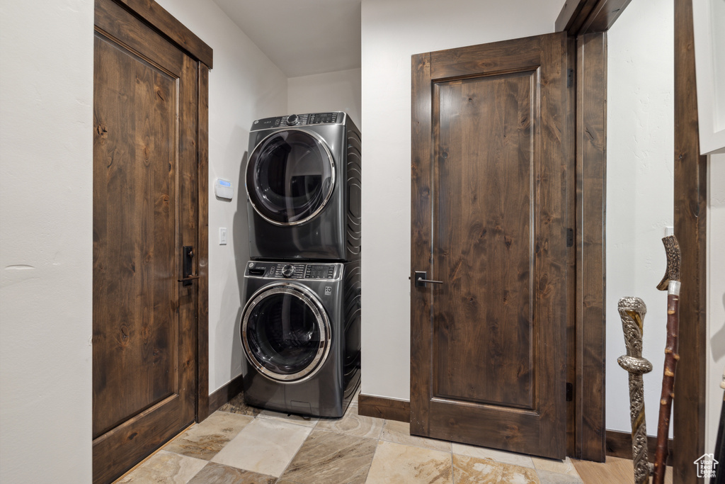 Washroom featuring stacked washer / dryer and baseboards