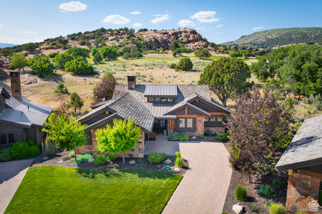 Aerial view of property and surrounding area featuring a mountain backdrop