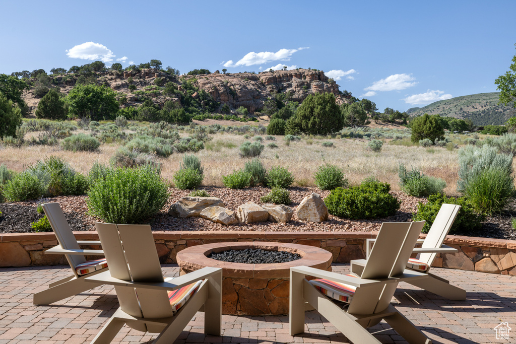 View of patio / terrace with a fire pit and a mountain view