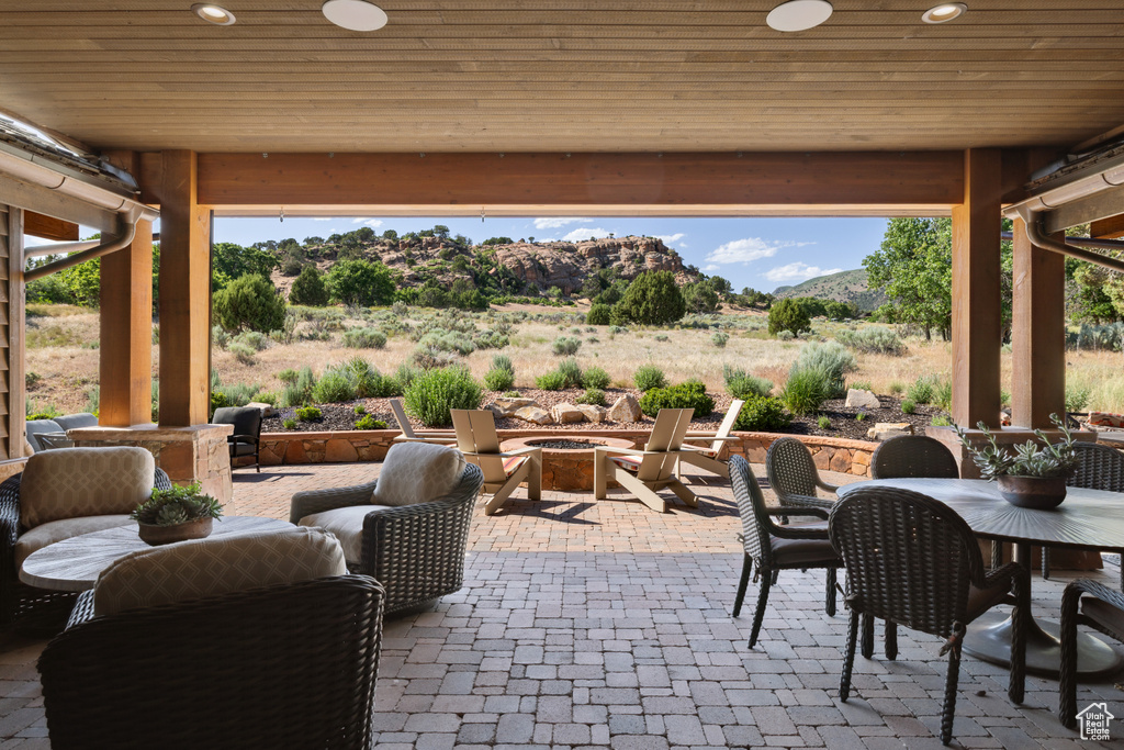 View of patio with an outdoor fire pit, outdoor dining area, and a mountain view