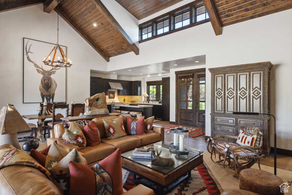Living room with wood finished floors, a chandelier, a wooden ceiling with exposed beams, and high vaulted ceiling