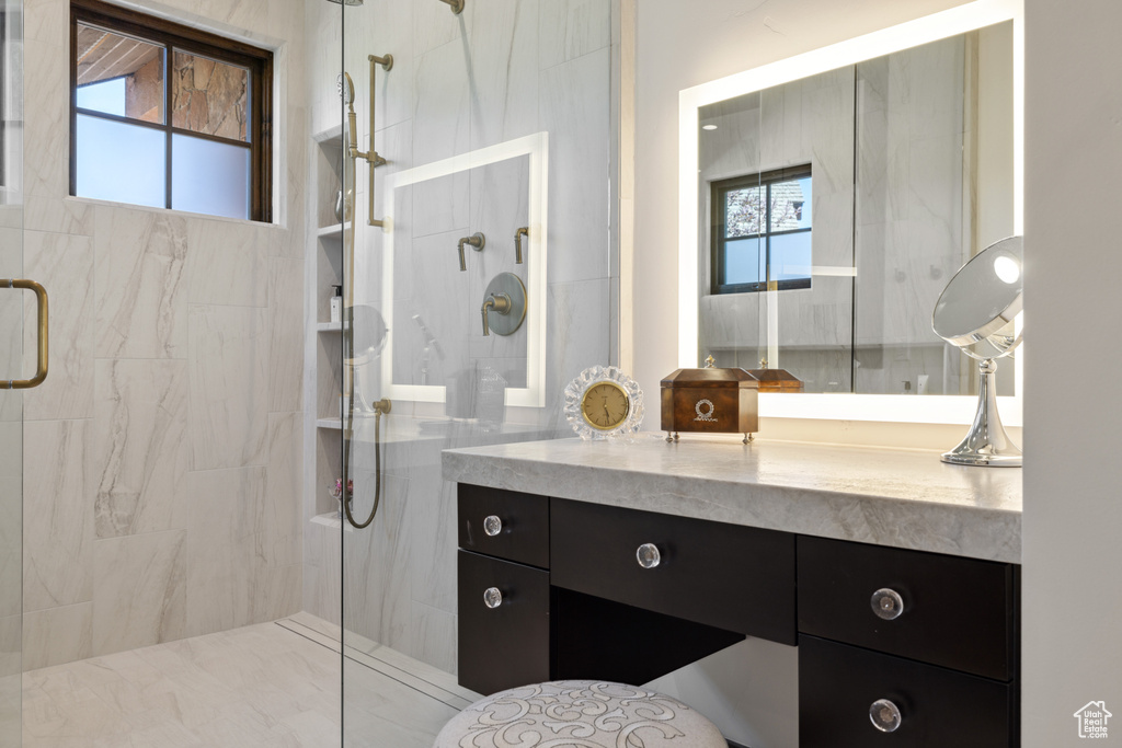 Bathroom with a marble finish shower and vanity