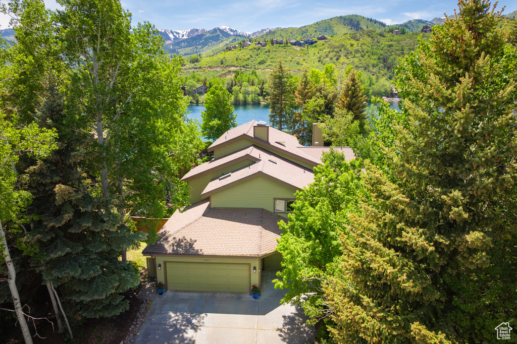 Aerial view of property and surrounding area featuring a water and mountain view