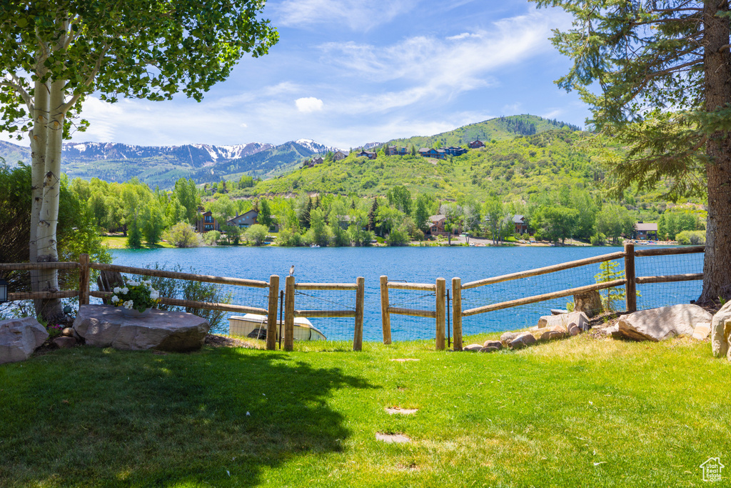 Dock with a lawn and a water and mountain view
