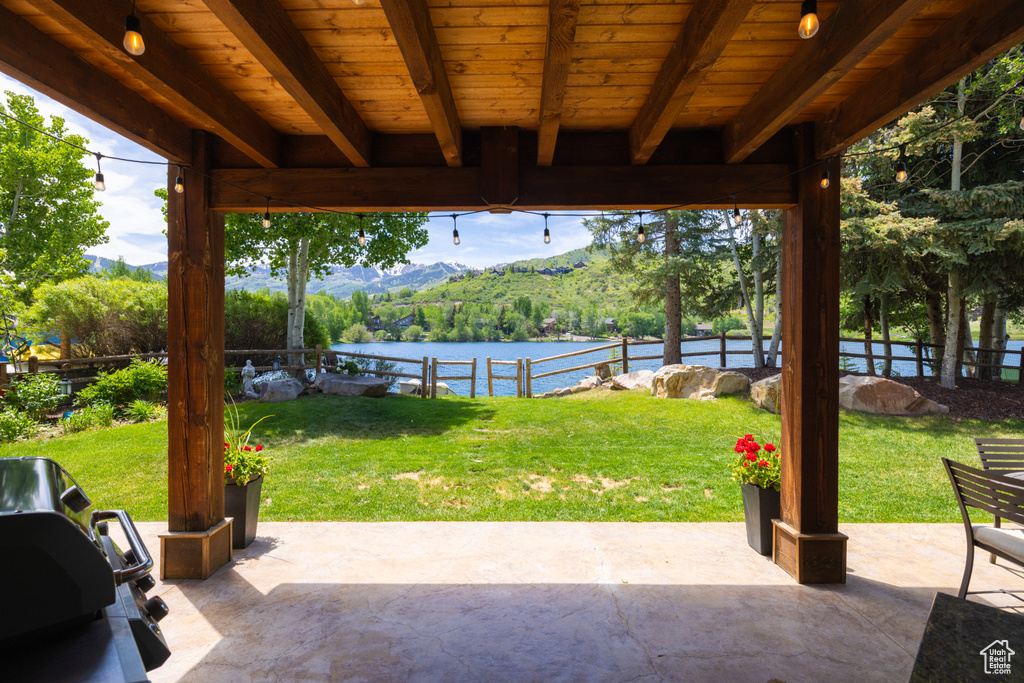 Fenced backyard featuring a patio area and a water and mountain view