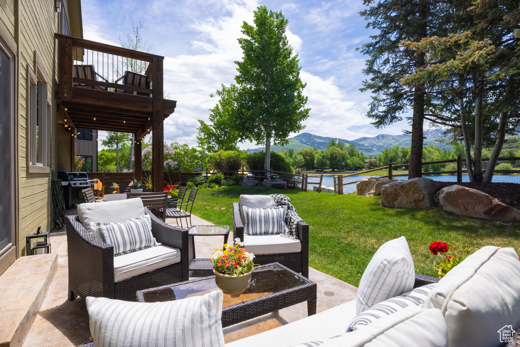 Patio / terrace featuring an outdoor hangout area, a yard, area for grilling, and a water and mountain view
