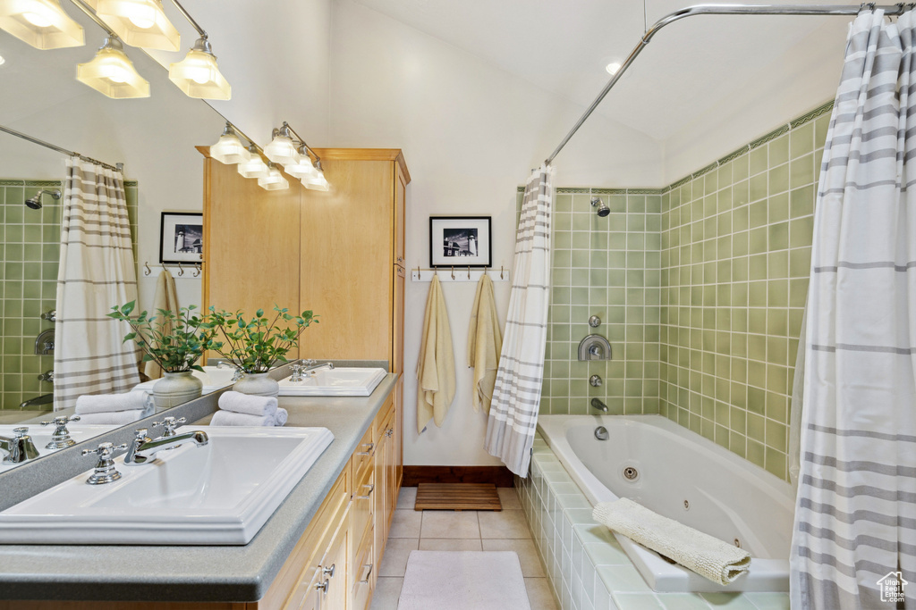 Full bath featuring tile patterned floors, double vanity, and a combined bath / shower with jetted tub