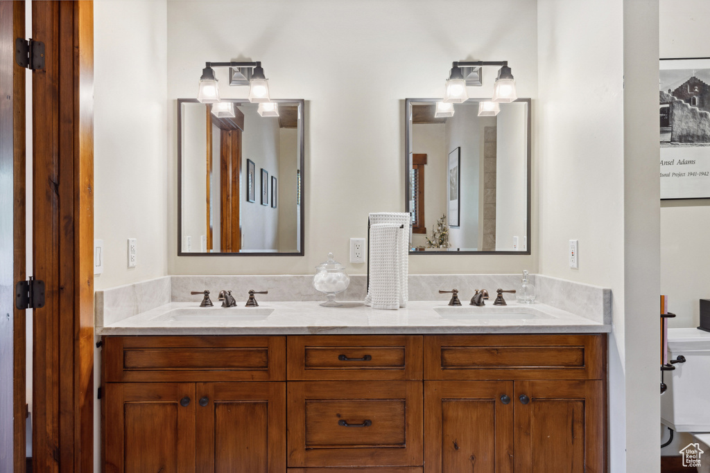 Full bath featuring double vanity and toilet