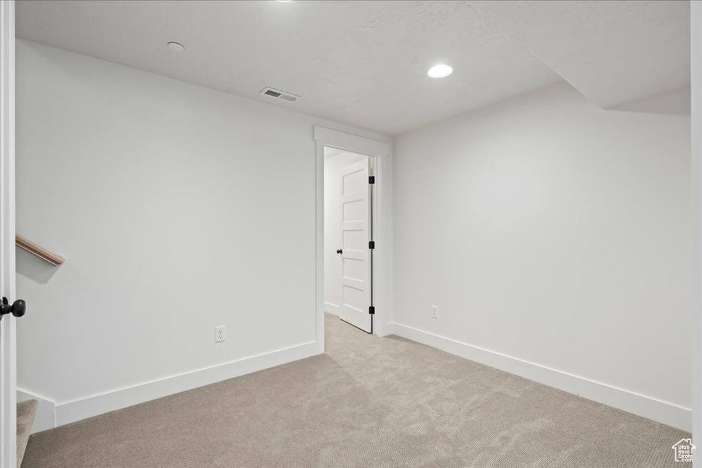 Carpeted empty room featuring baseboards and recessed lighting