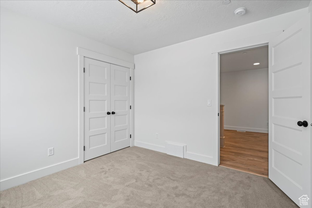 Unfurnished bedroom with carpet floors and a closet