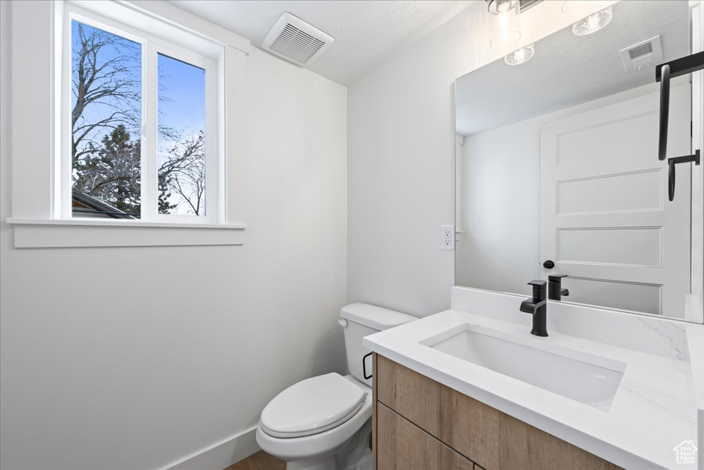 Half bath featuring vanity and toilet