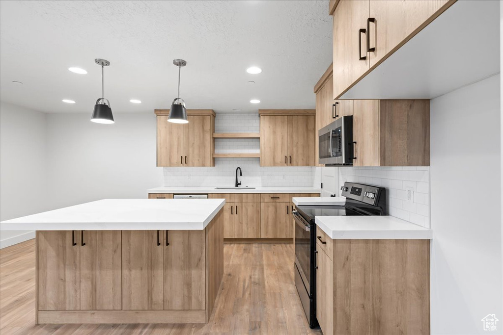 Kitchen with electric range, stainless steel microwave, light brown cabinets, open shelves, and tasteful backsplash