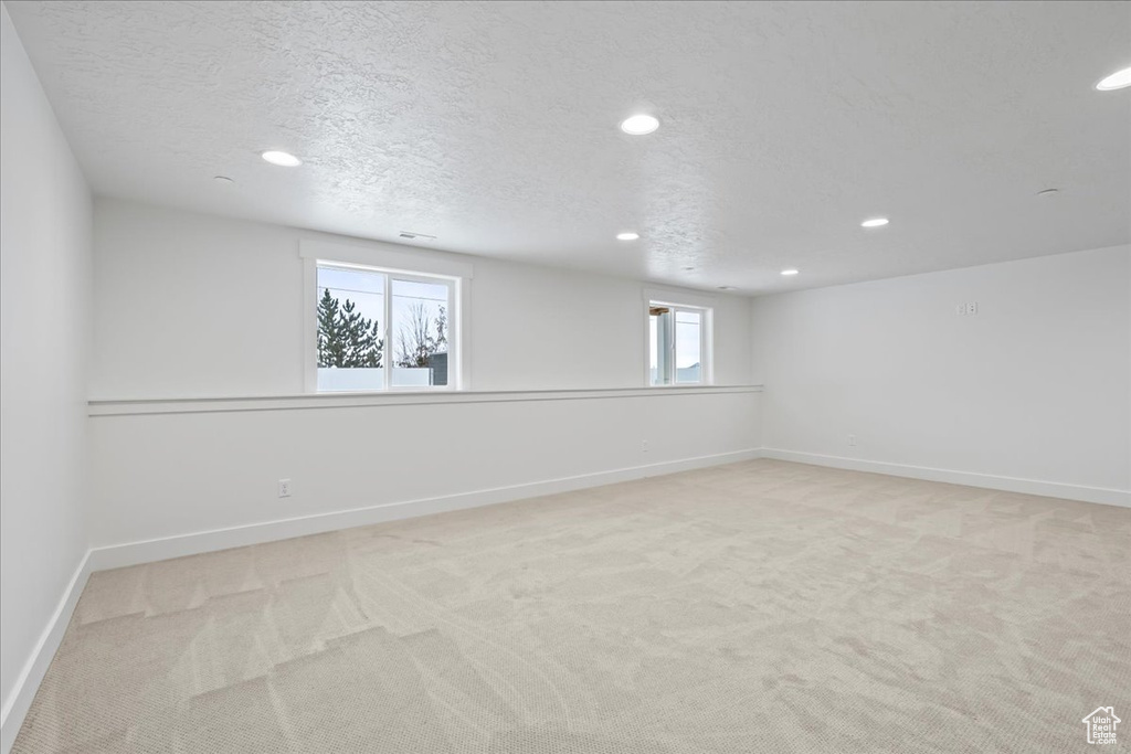 Spare room with recessed lighting, light carpet, and a textured ceiling