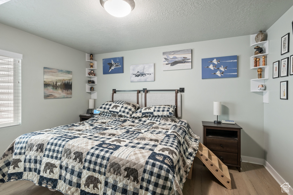Bedroom featuring wood finished floors and a textured ceiling