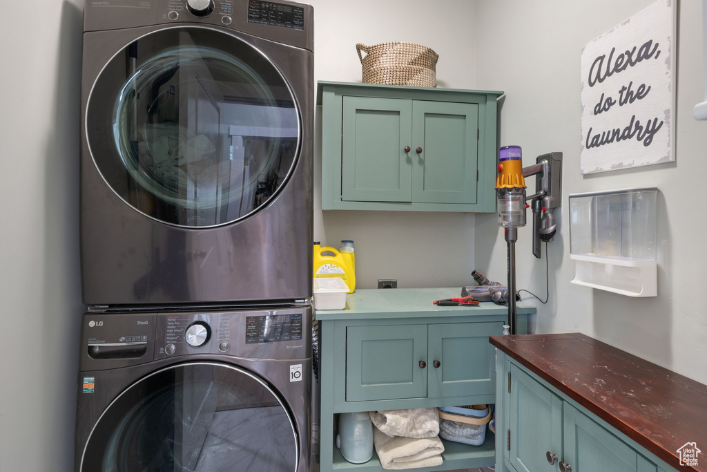 Washroom featuring cabinet space and estacked washer and dryer