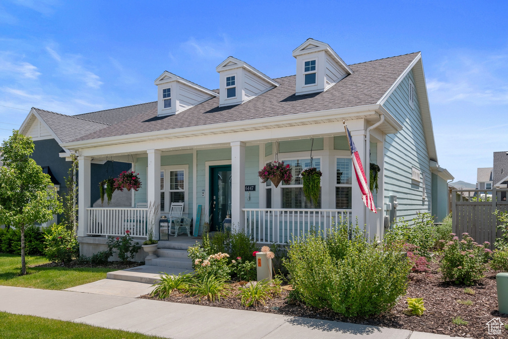 View of front of property with covered porch and a shingled roof
