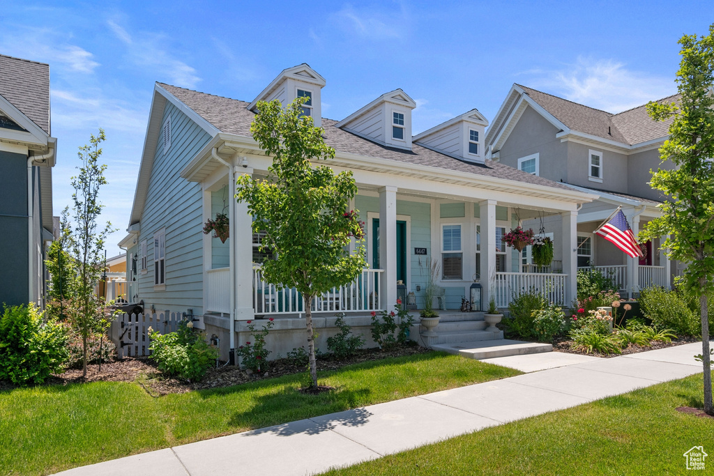 View of front facade featuring a porch and a front yard