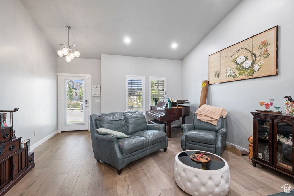 Living area with lofted ceiling, light wood-style floors, a chandelier, and recessed lighting