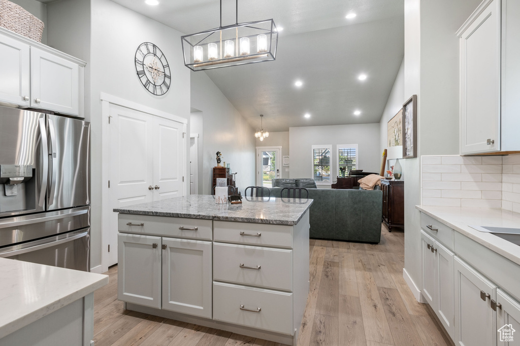 Kitchen featuring stainless steel refrigerator with ice dispenser, a chandelier, backsplash, recessed lighting, and white cabinets