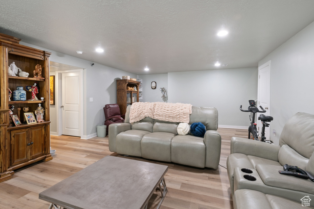 Living area featuring light wood finished floors and recessed lighting