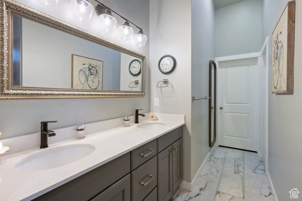 Bathroom featuring marble look tile flooring and double vanity