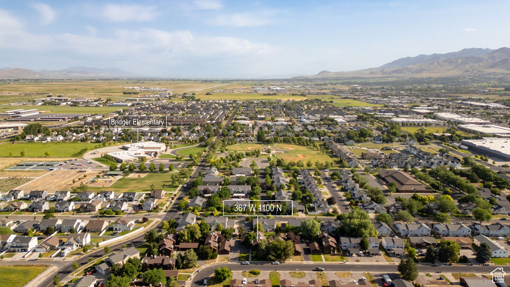Aerial overview of property's location featuring a mountain backdrop and nearby suburban area