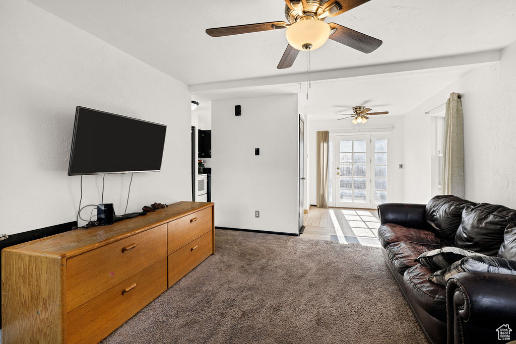 Living room featuring ceiling fan and light carpet