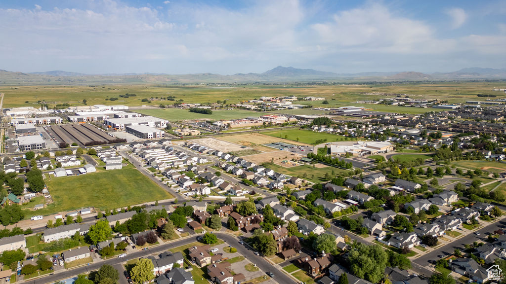Aerial view of property and surrounding area with a mountain backdrop