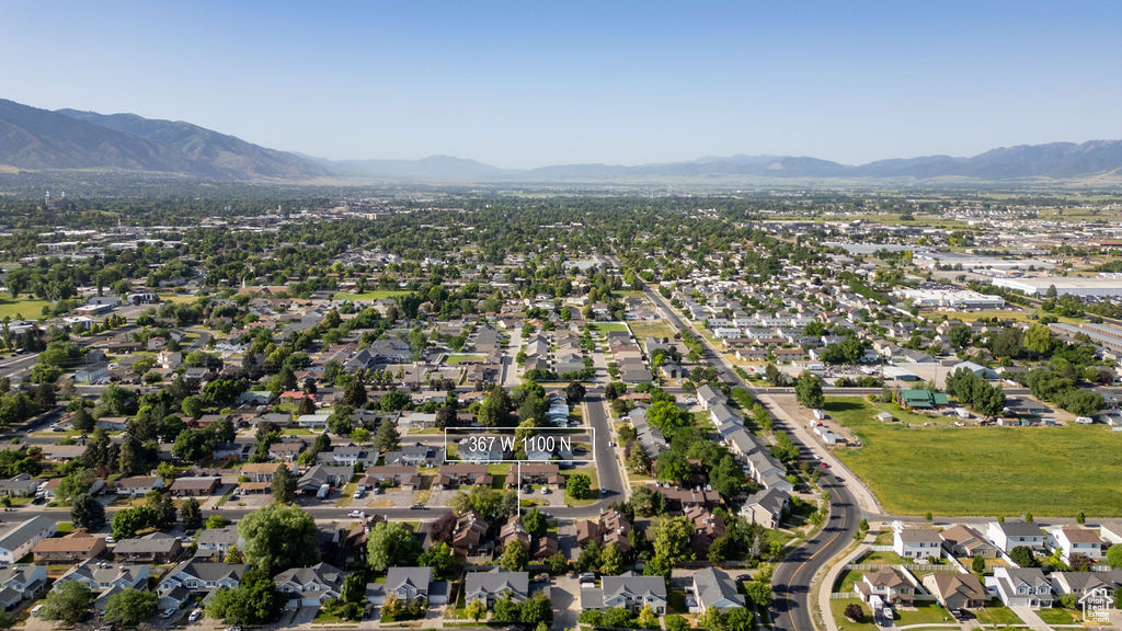 Aerial view of property and surrounding area with a mountainous background and nearby suburban area