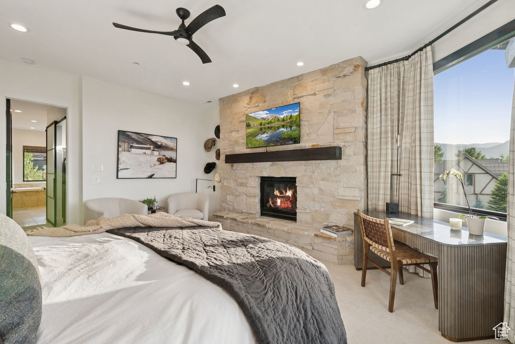Bedroom with carpet, recessed lighting, a stone fireplace, and ensuite bath