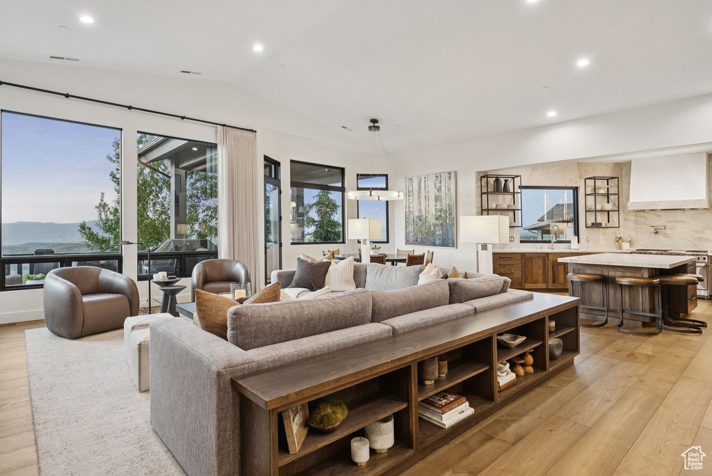 Living area featuring light wood-style flooring, vaulted ceiling, recessed lighting, and a mountain view