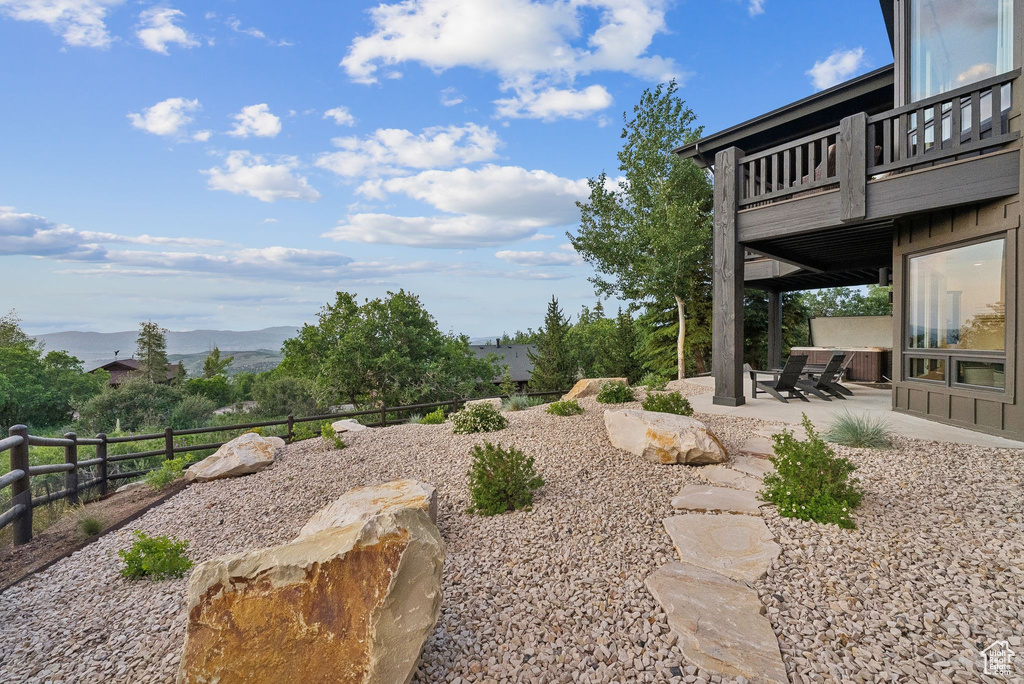 View of yard featuring a patio, a mountain view, and a balcony