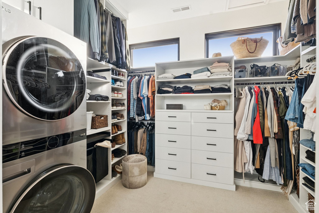 Laundry room featuring stacked washer and clothes dryer and carpet