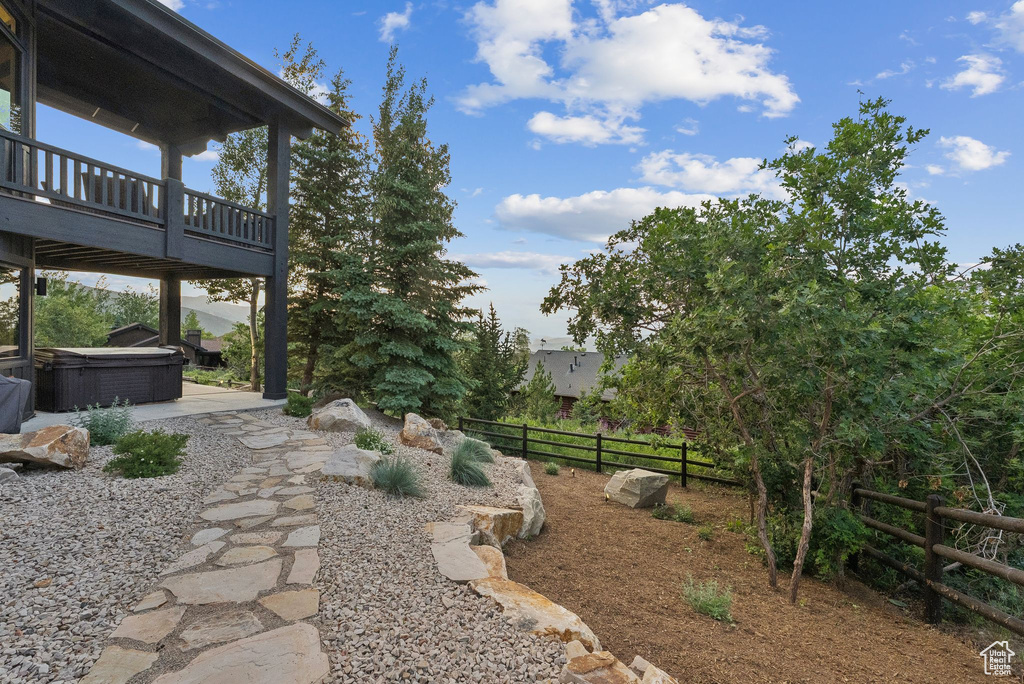 View of yard featuring a hot tub, a wooden deck, and a patio area