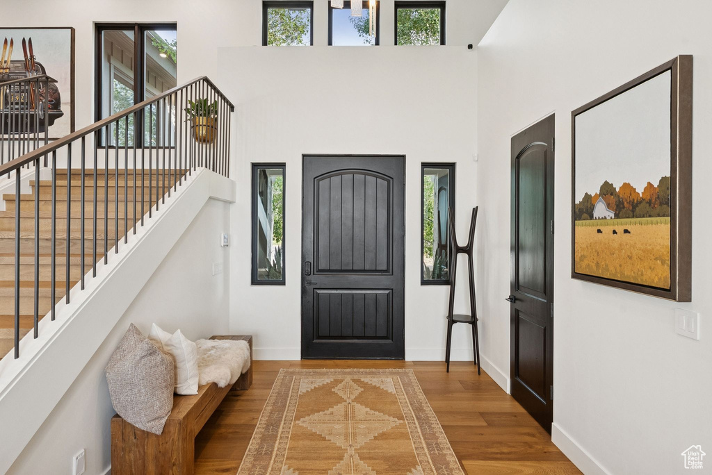 Entrance foyer featuring plenty of natural light, wood finished floors, stairs, and a towering ceiling