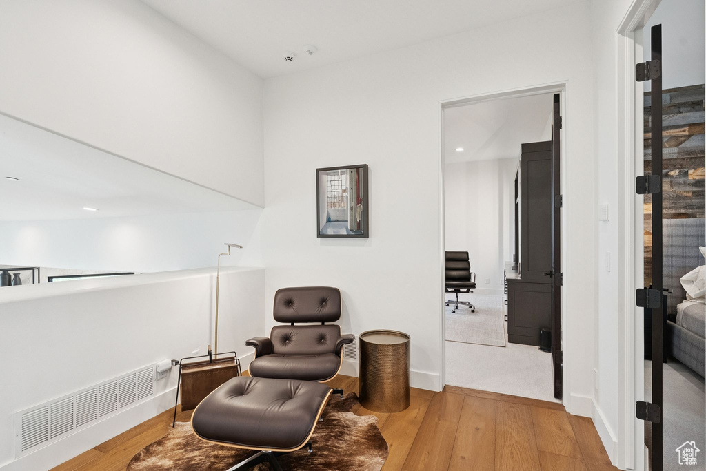 Living area featuring light wood-style flooring, recessed lighting, and radiator