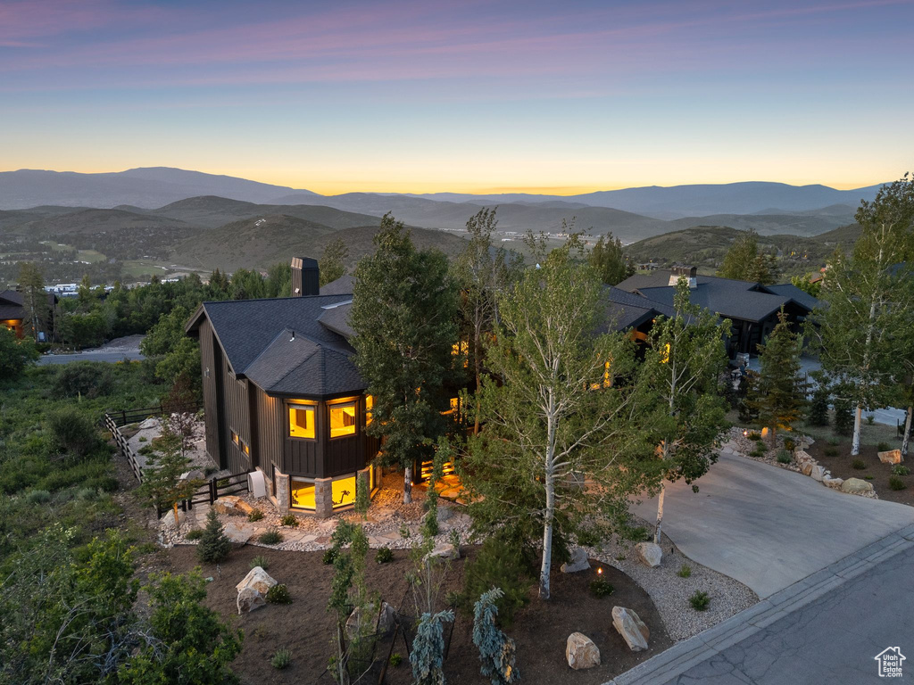 View of front of home with a chimney, a mountain view, and a shingled roof