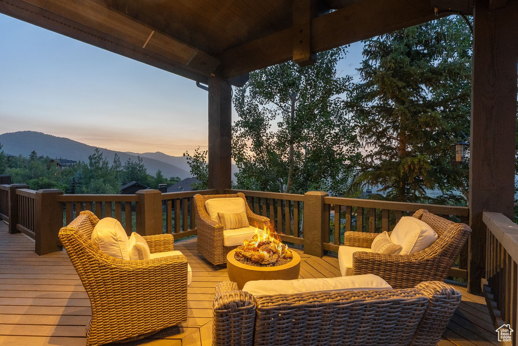 Deck at dusk with an outdoor fire pit and a mountain view