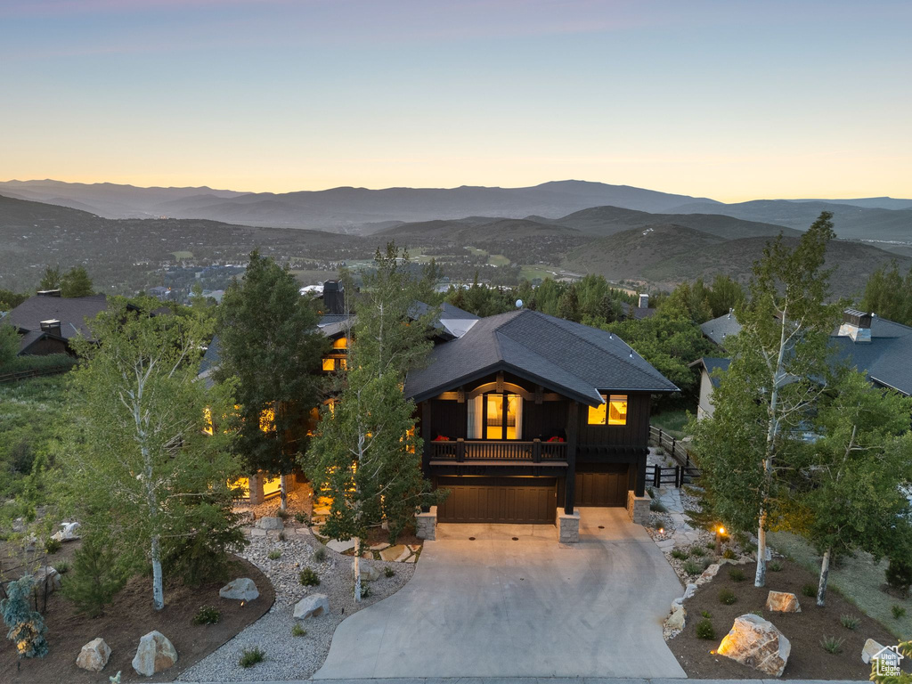 View of front of property with a garage, a mountain view, driveway, and stairway
