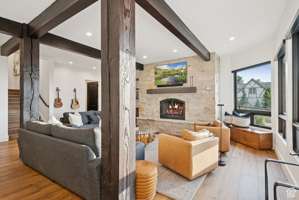 Living room with beamed ceiling, hardwood / wood-style flooring, a fireplace, stairs, and recessed lighting